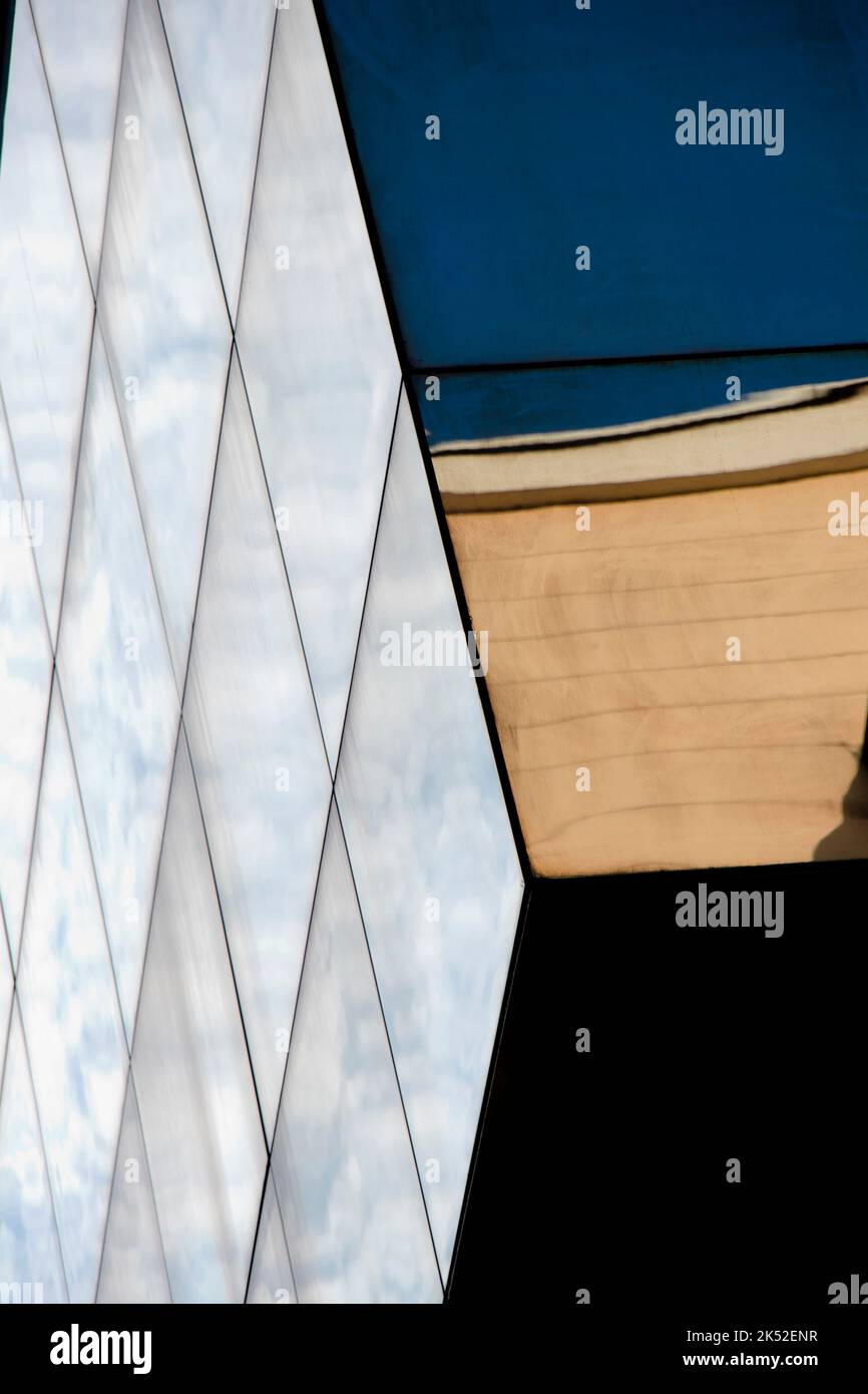 Architecture abstraite - façade en verre, coin de bâtiment avec reflets de ciel, vue à angle bas Banque D'Images
