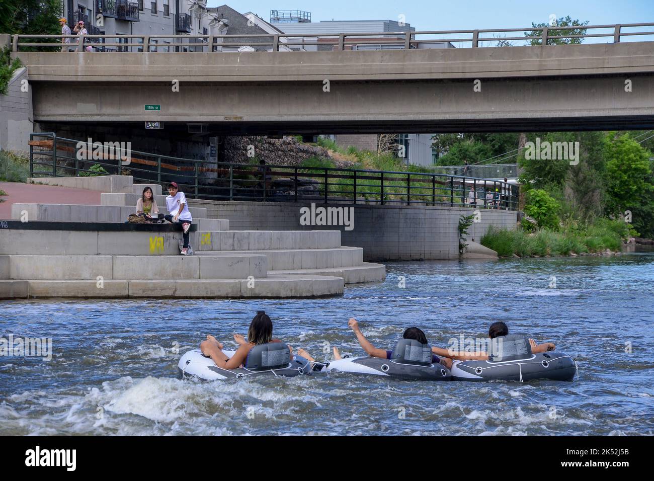 Trois amis flottent sur la South Platte River lors d'une journée chaude à bord d'un bateau à Denver Colorado Banque D'Images