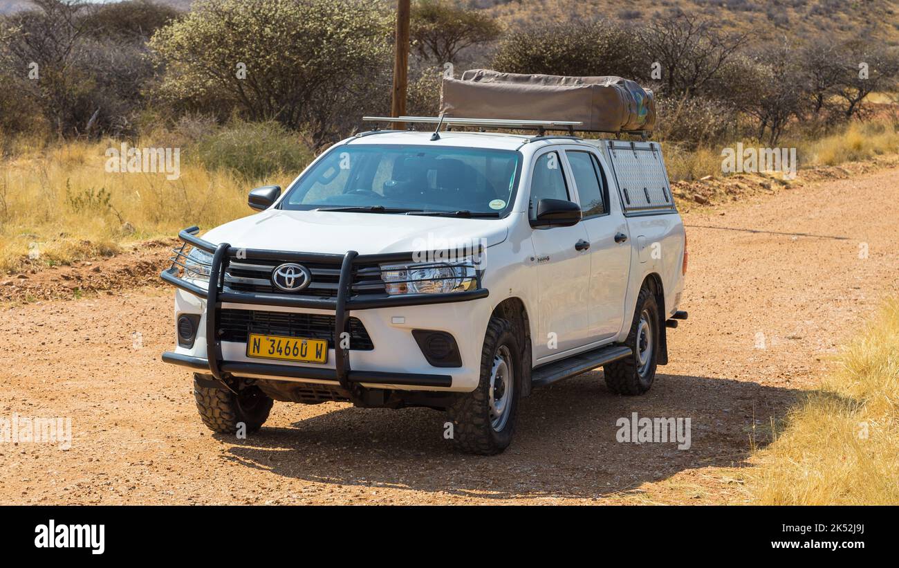 Windhoek, Namibie - 28 septembre 2018 : voiture de location typique de 4x4 en Namibie équipée d'un équipement de camping et d'une tente sur le toit qui conduit sur une route de terre à travers le Banque D'Images Windhoek, Namibie - 28 septembre 2018 : voiture de location typique de 4x4 en Namibie équipée d'un équipement de camping et d'une tente sur le toit qui conduit sur une route de terre à travers le Banque D'Images