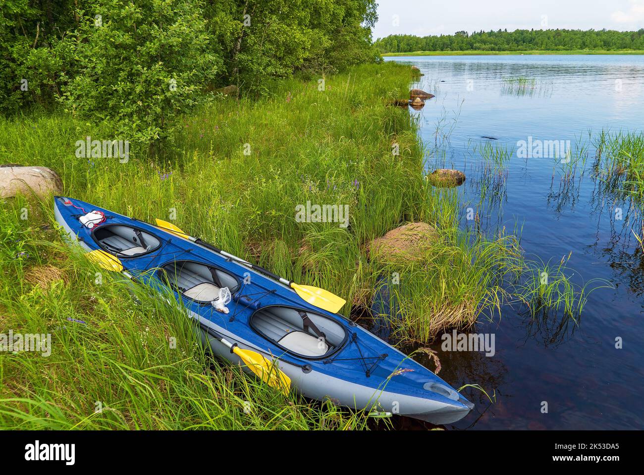 Kayak bleu sur la rive du lac Ladoga. Carélie Banque D'Images