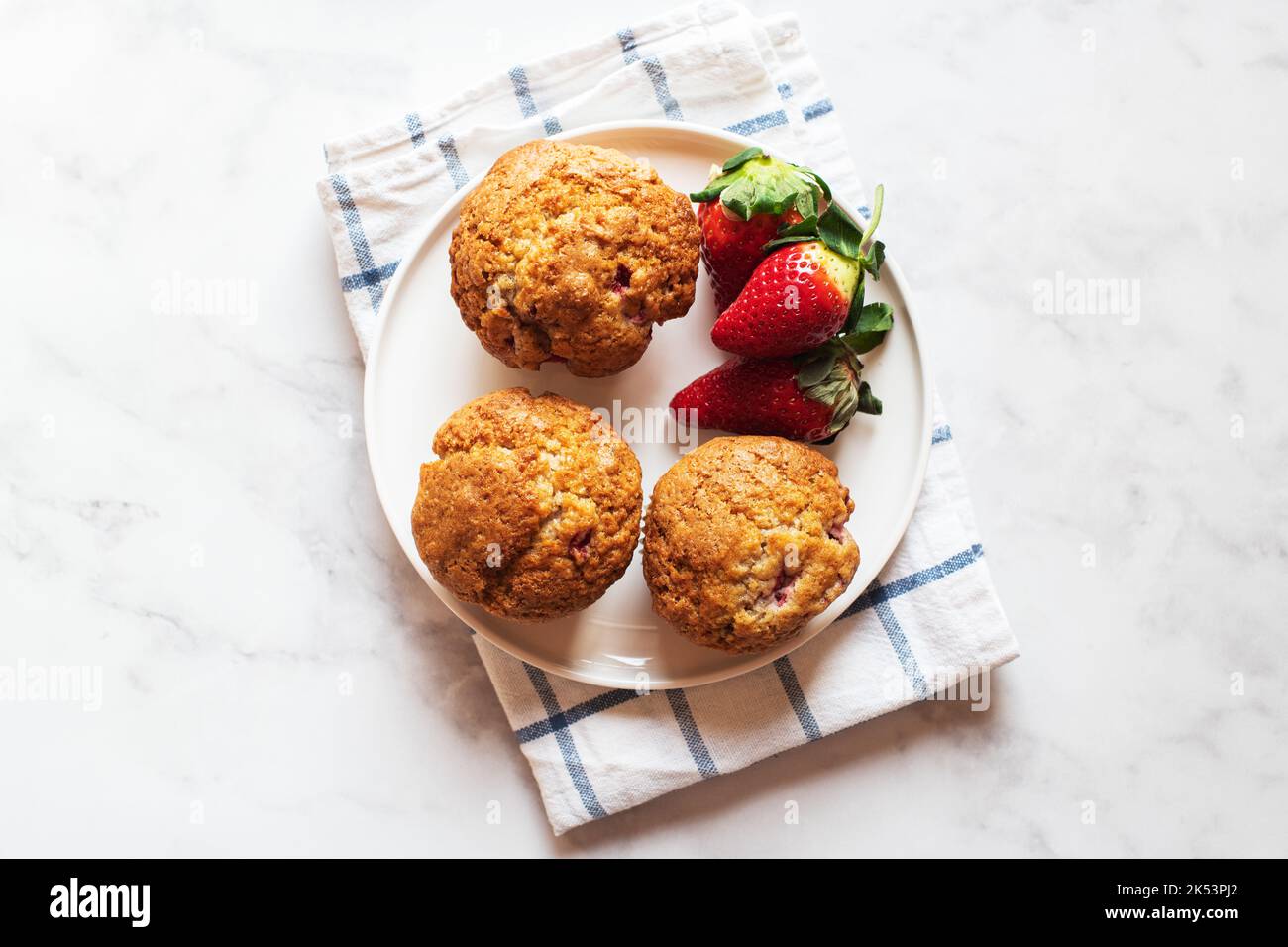 Muffins aux fraises servis dans une assiette sur fond de marbre. Vue de dessus. Banque D'Images