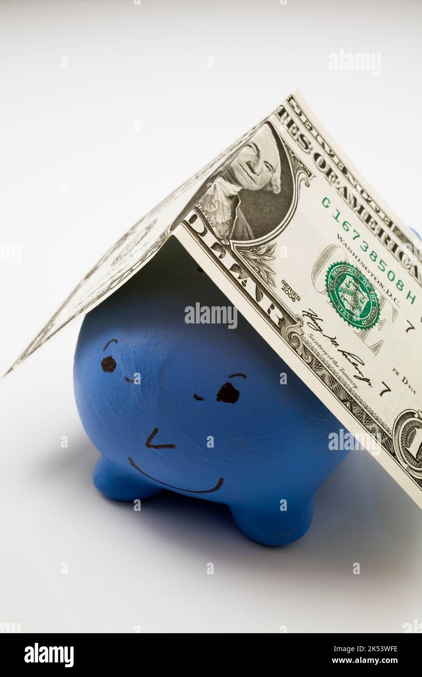 Billet d'un dollar sur la tirelire en céramique bleue. Banque D'Images