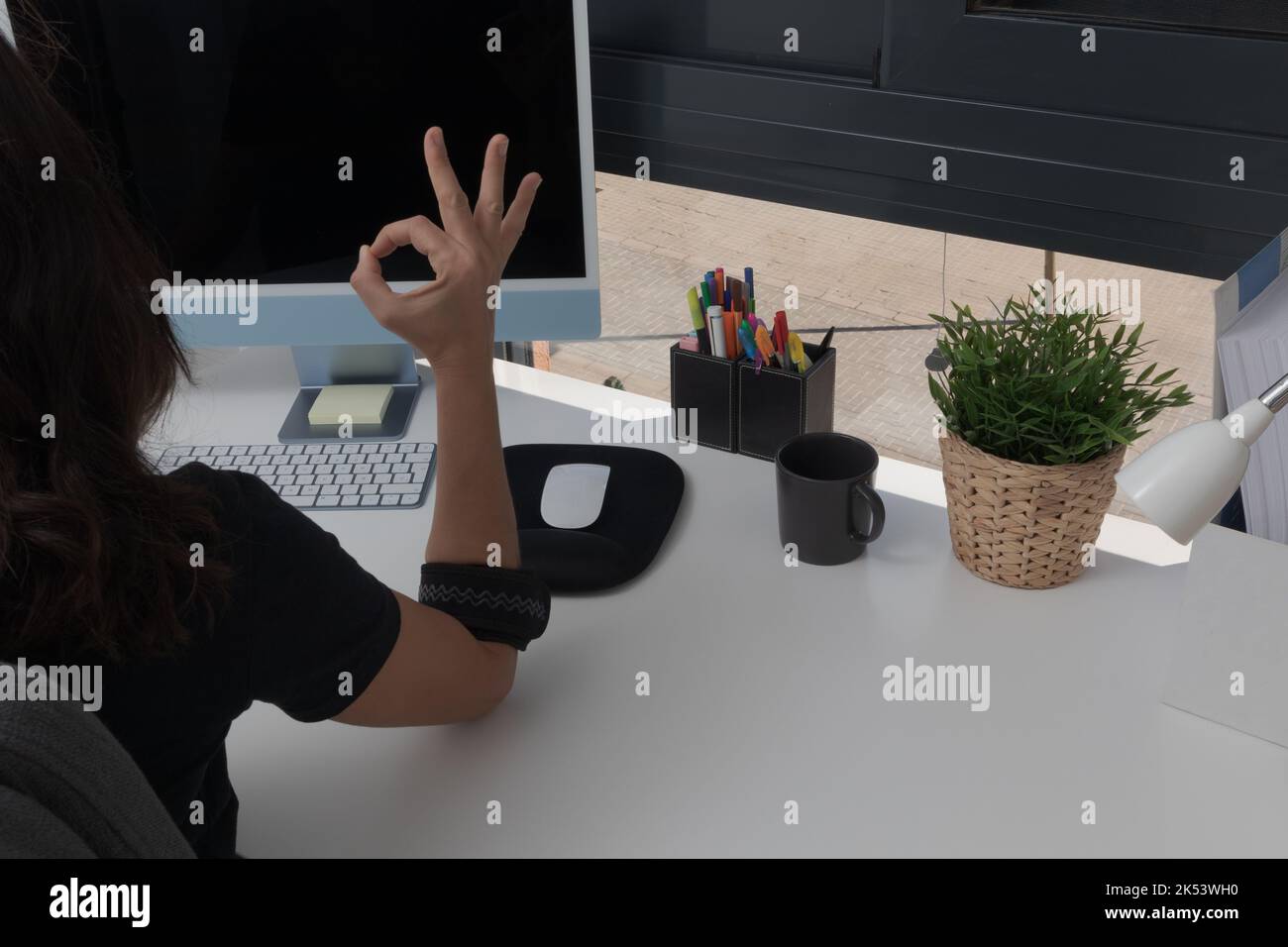 Un bras avec coussinet de coude pour tendinite epicondylite avec un geste ok Banque D'Images