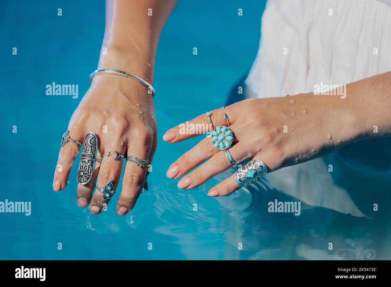 Belle femme tzigane montre des bijoux boho, des anneaux avec des pierres turquoise sur les mains