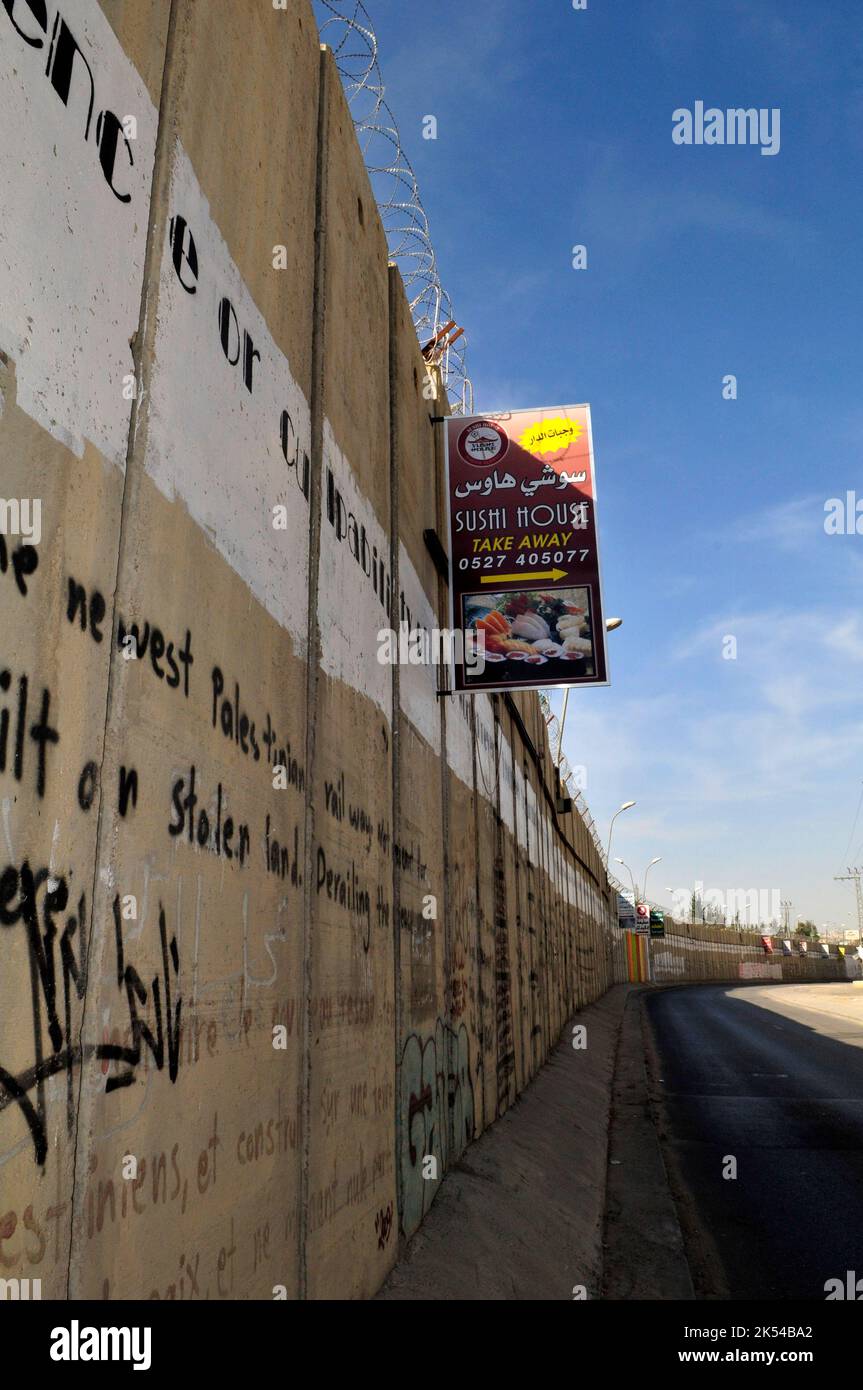 Des publicités pendues sur le mur-barrière construit par Israël en Cisjordanie, en Palestine. Banque D'Images