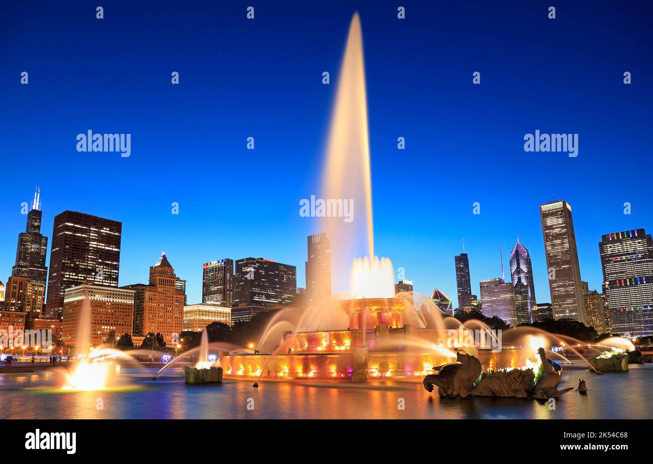 Horizon de Chicago illuminé au crépuscule avec fontaine colorée de Buckingham en premier plan, Illinois, États-Unis Banque D'Images