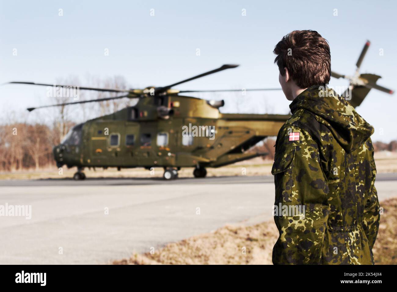 À la zone de dépôt. Un jeune soldat regardant un hélicoptère de l'armée. Banque D'Images À la zone de dépôt. Un jeune soldat regardant un hélicoptère de l'armée. Banque D'Images