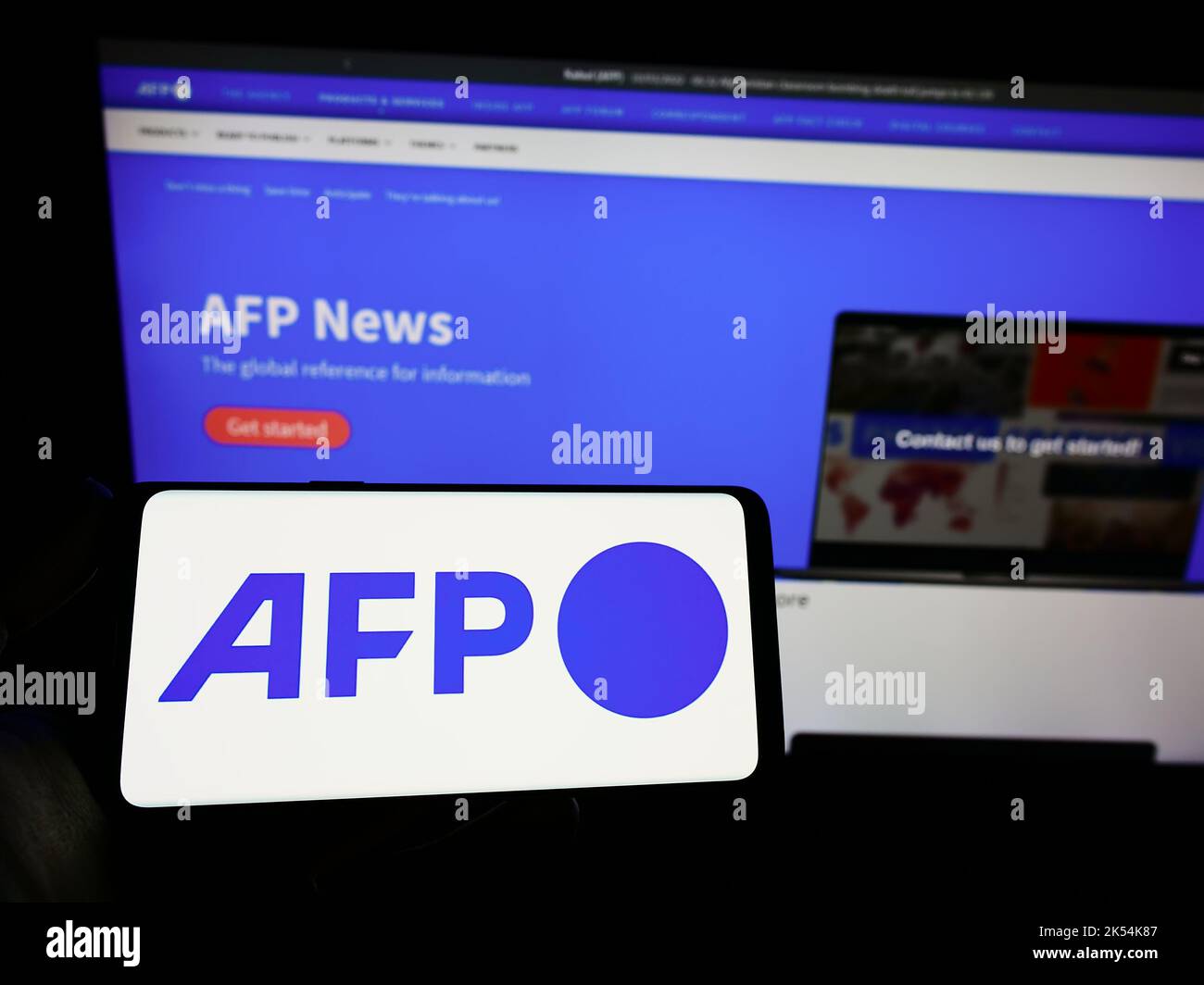 Personne tenant un smartphone avec le logo de l'agence de presse Agence France-presse (AFP) à l'écran devant le site. Mise au point sur l'affichage du téléphone. Banque D'Images