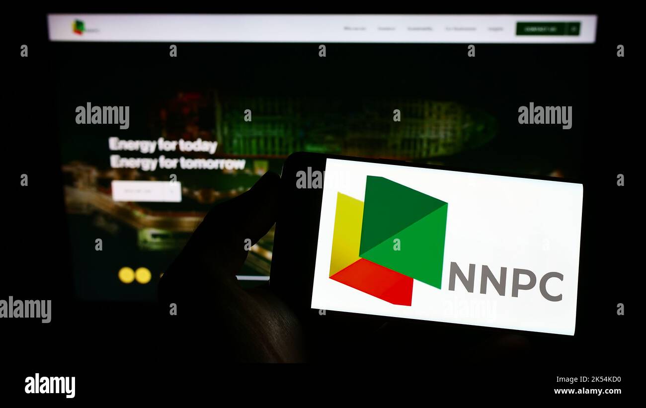 Personne tenant un smartphone avec le logo de la compagnie pétrolière nationale nigériane limitée (NNPC) à l'écran devant le site Web. Mise au point sur l'affichage du téléphone. Banque D'Images