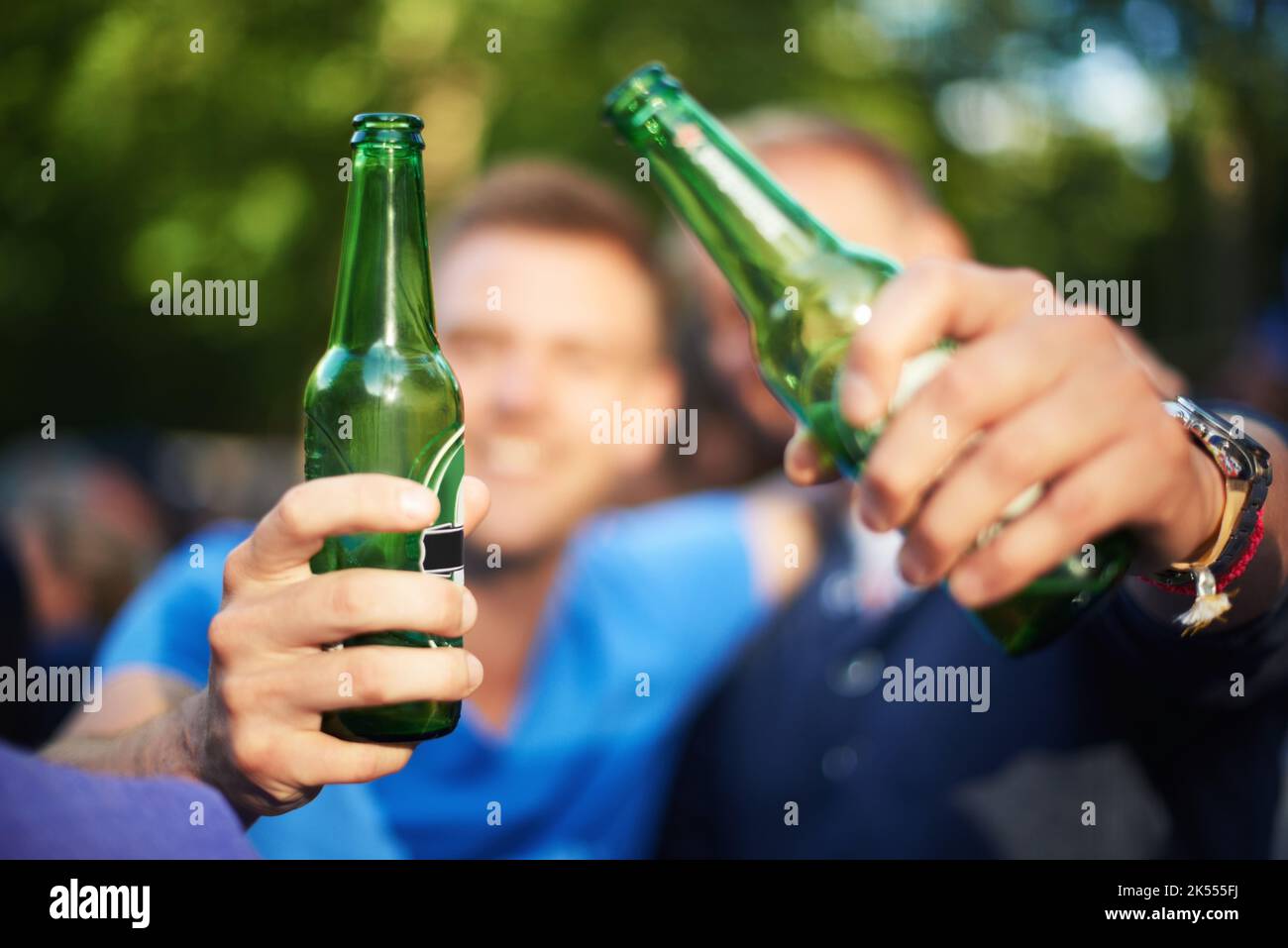 Aux bons moments. Gros plan sur l'image de deux gars qui toaster leurs bouteilles de bière lors d'un festival de musique. Banque D'Images