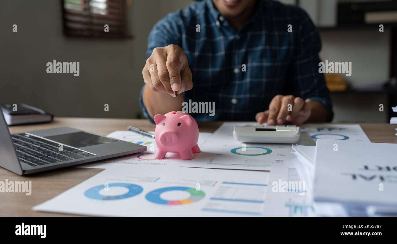 Homme heureux de mettre la main d'argent pièce de piggy pour économiser l'argent richesse et le concept de comptabilité financière Banque D'Images