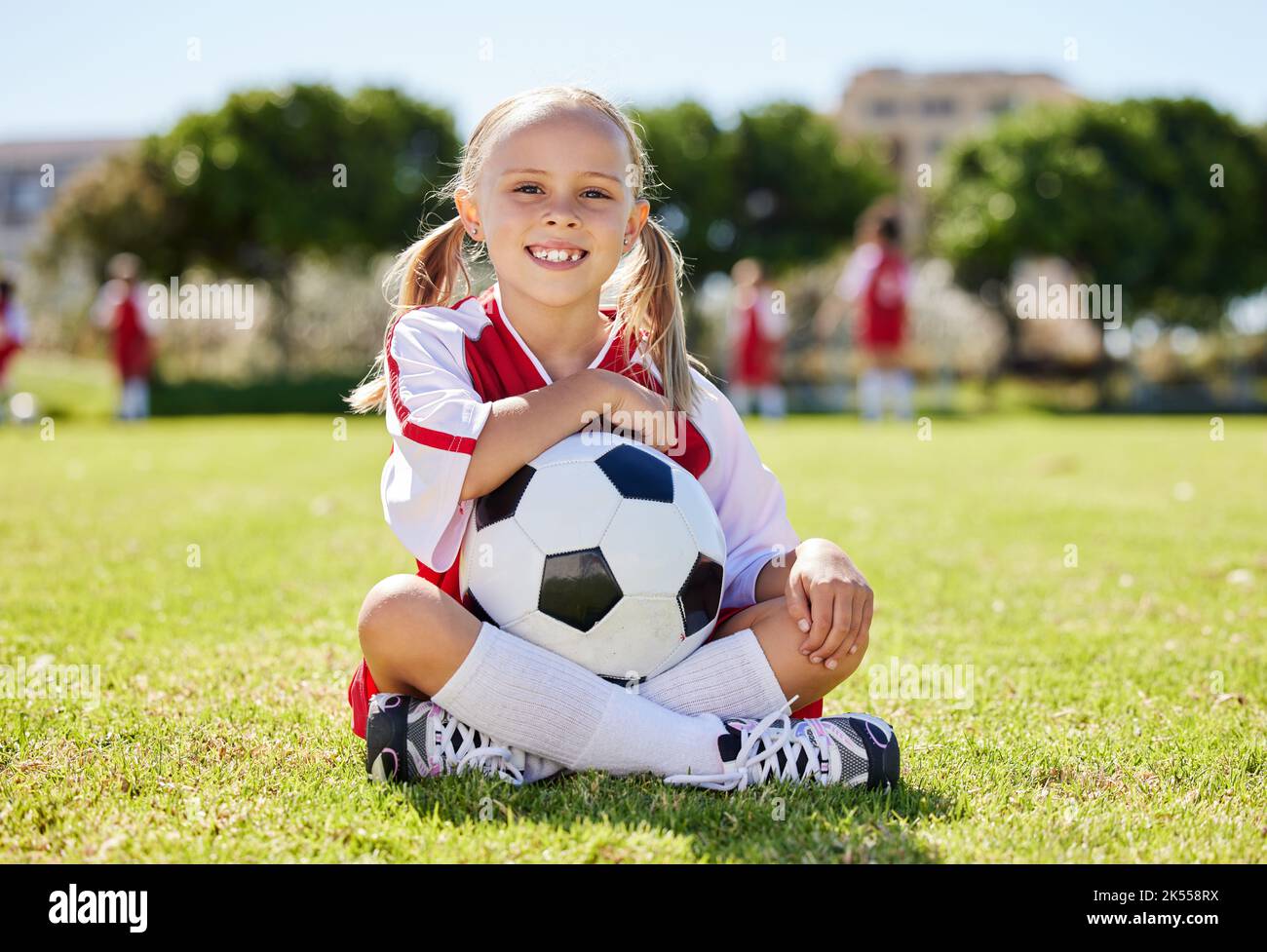 Ballon de football, jeune fille sportive et assis sur le terrain, entraînement pour les jeunes compétition match jouant à l'herbe du stade. Portrait, jeune athlète ou joueur aiment Banque D'Images