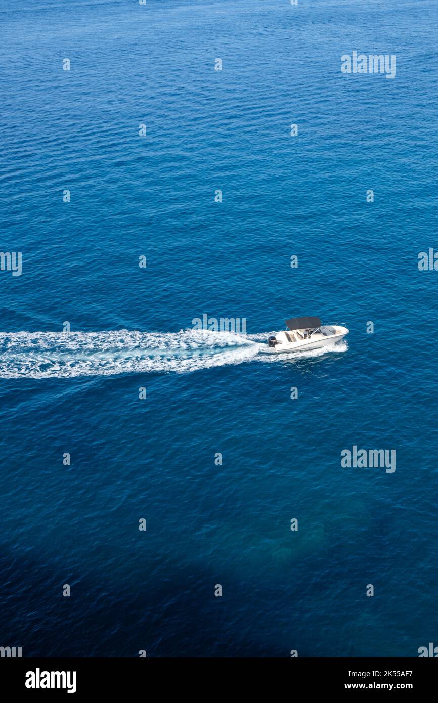 Un bateau de samll traverse la mer bleu profond au large de la côte de Croatie. Banque D'Images