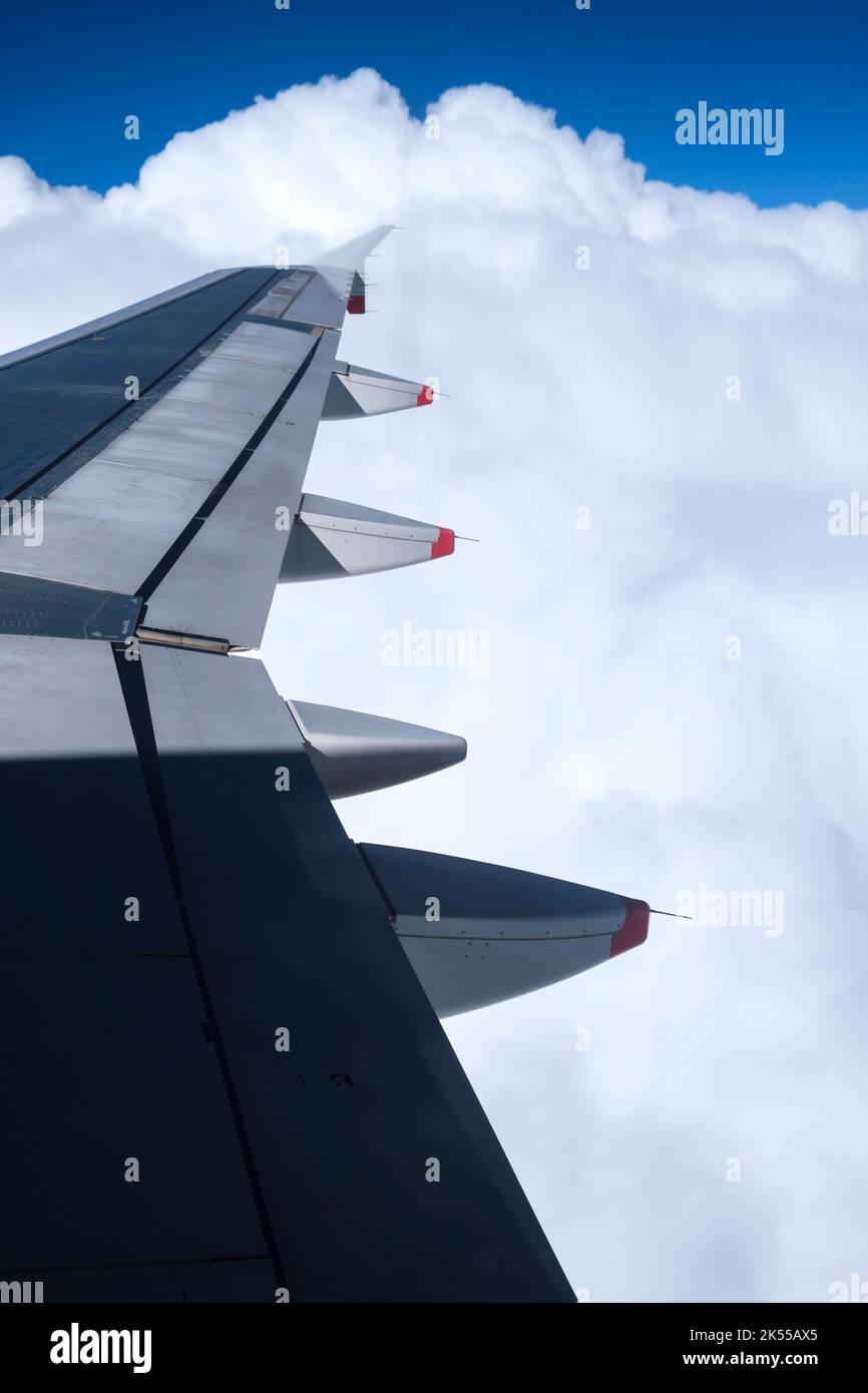 Vue par la fenêtre d'un avion à l'aile avec des formations de nuages spectaculaires. Banque D'Images
