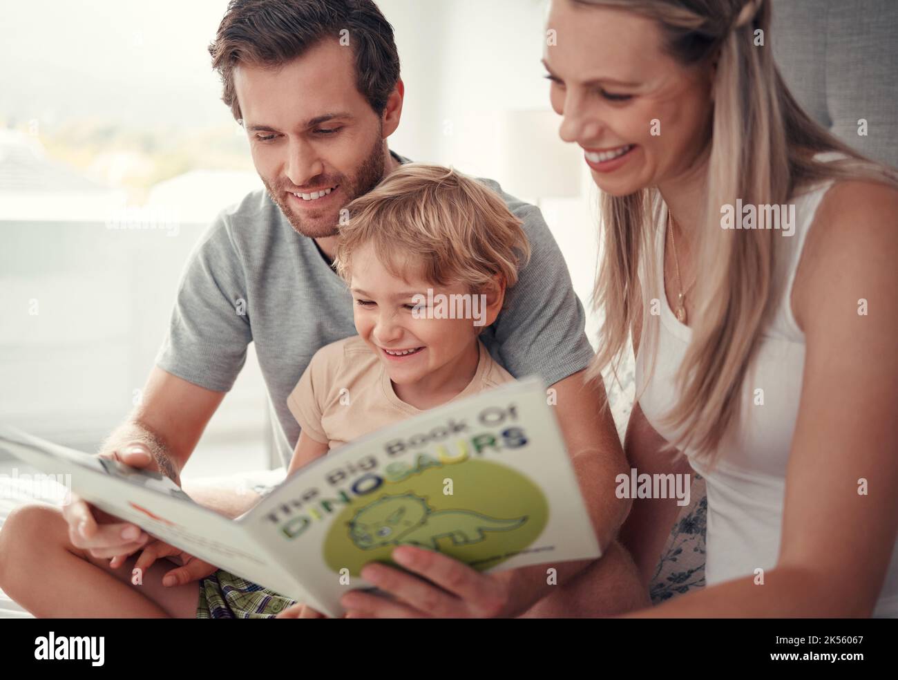 Parents, enfants et lecture de livres de dinosaures dans la maison familiale pour le plaisir éducatif, l'apprentissage et le développement heureux en Australie. Maman, papa et gamin jouant Banque D'Images