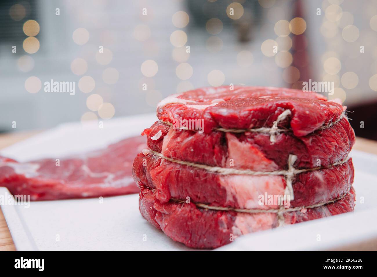 Un morceau de bœuf vieilli sur une assiette. Gros plan, mise au point sélective. Viande pour steaks en cours de cuisine. Banque D'Images