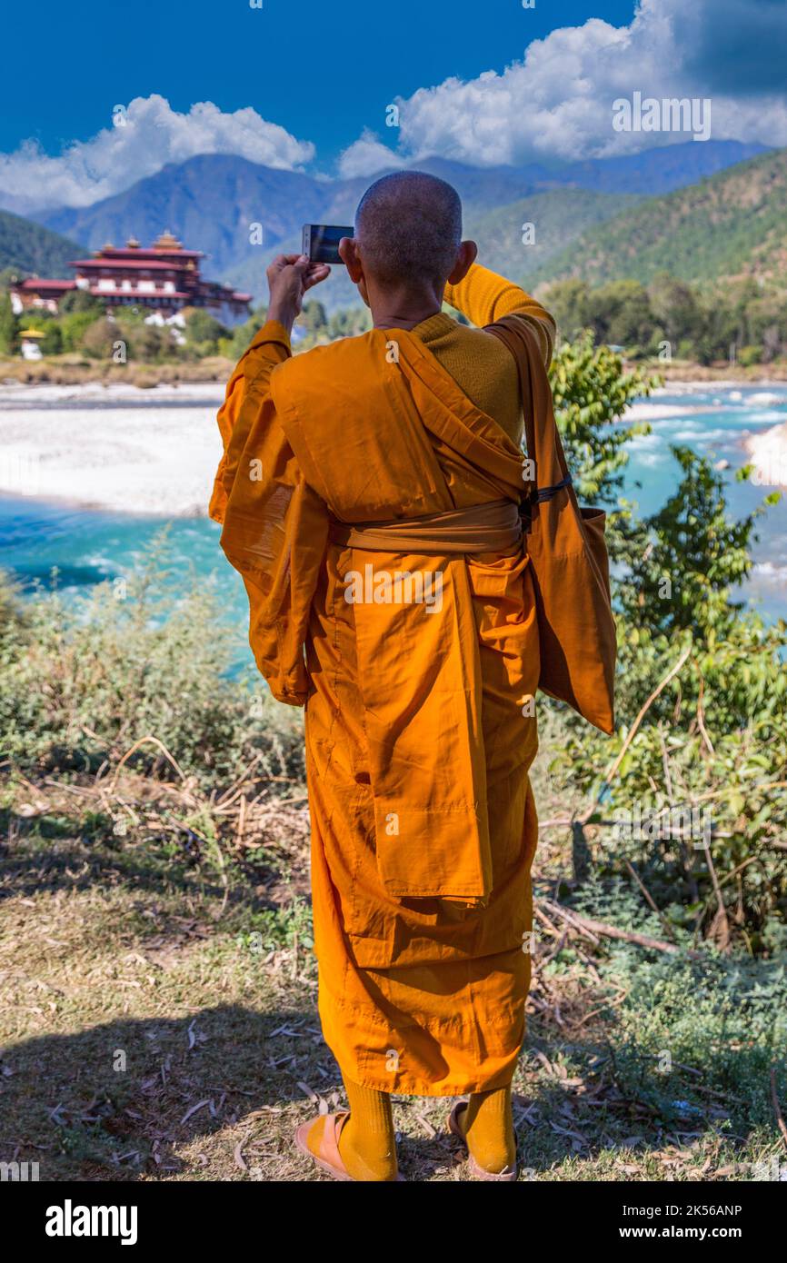 Punakha, Bhoutan. Le moine bouddhiste photographier le Punakha Dzong (forteresse/Monastère) avec son téléphone cellulaire. Banque D'Images