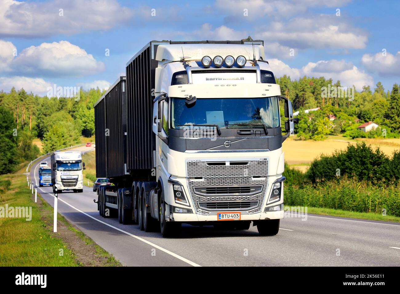 Trois camions lourds, le camion Volvo FH16 blanc à l'avant, tractez des remorques le long de l'autoroute un jour d'été. Salo, Finlande. 25 août 2022. Banque D'Images