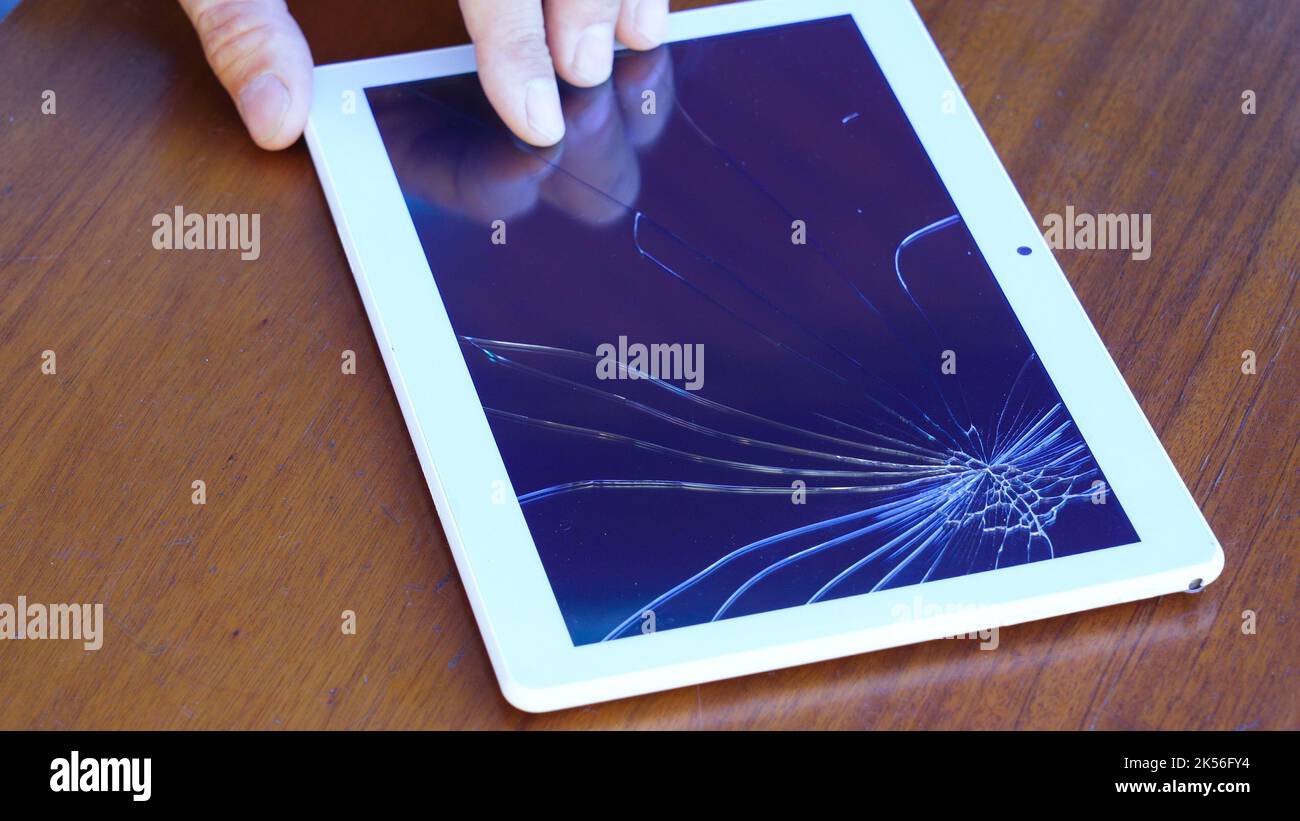 Tablette avec écran en verre cassé sur la table. Banque D'Images