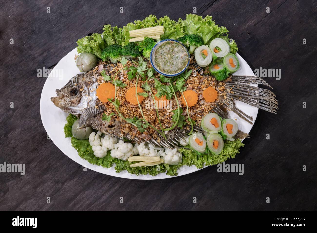 Délicieuse garniture de gourami géant au poisson frits avec de l'ail croustillant et une salade d'herbes avec Spicy sur céramique verte. Authentique cuisine thaïlandaise, vue sur le dessus, Selectiv Banque D'Images