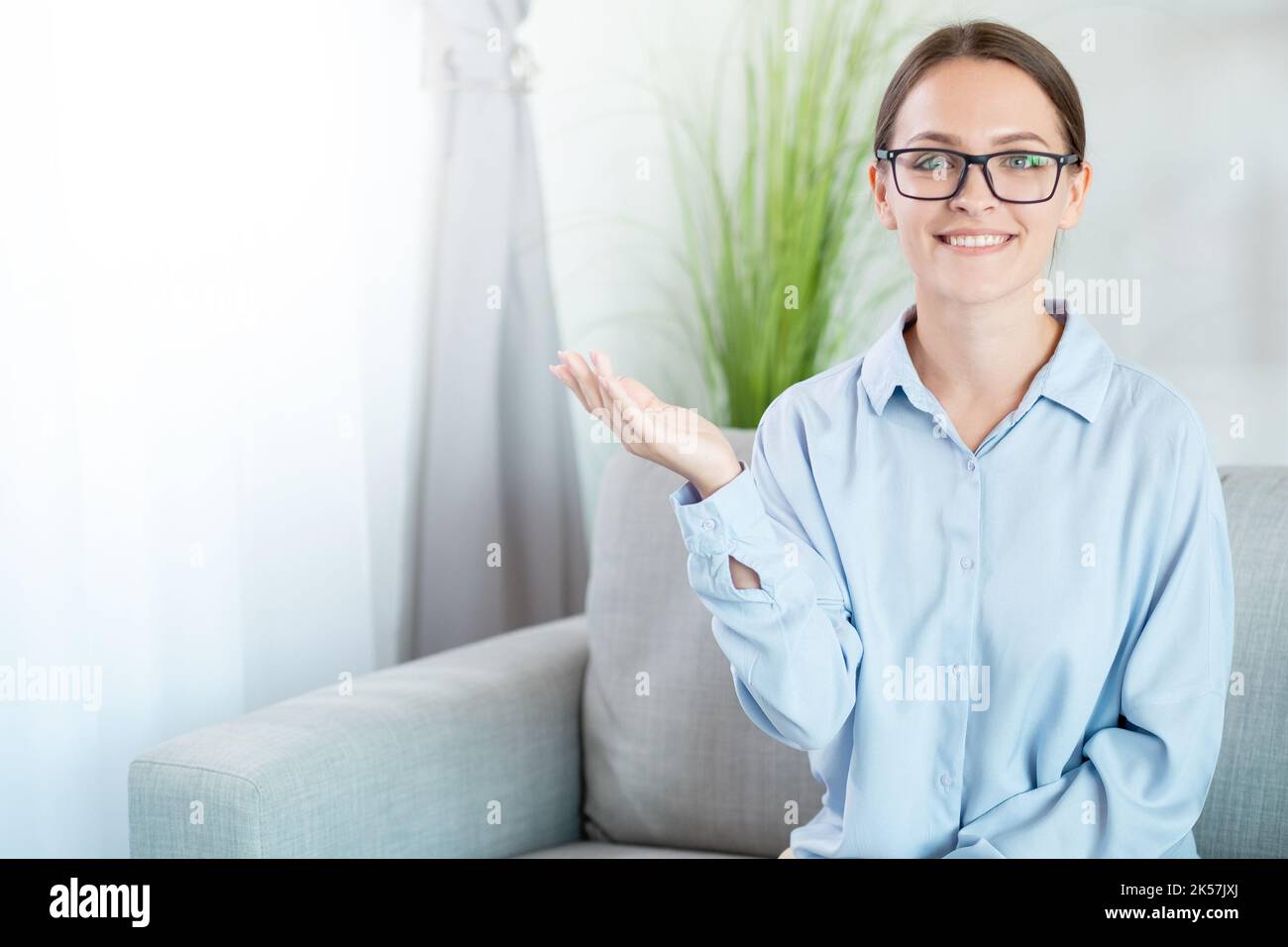 Publicité de personnes. Conseils d'experts. Offre spéciale. Confiante gaie souriante femme d'affaires intelligente en lunettes recommandant quelque chose sur l'espace libre à l Banque D'Images
