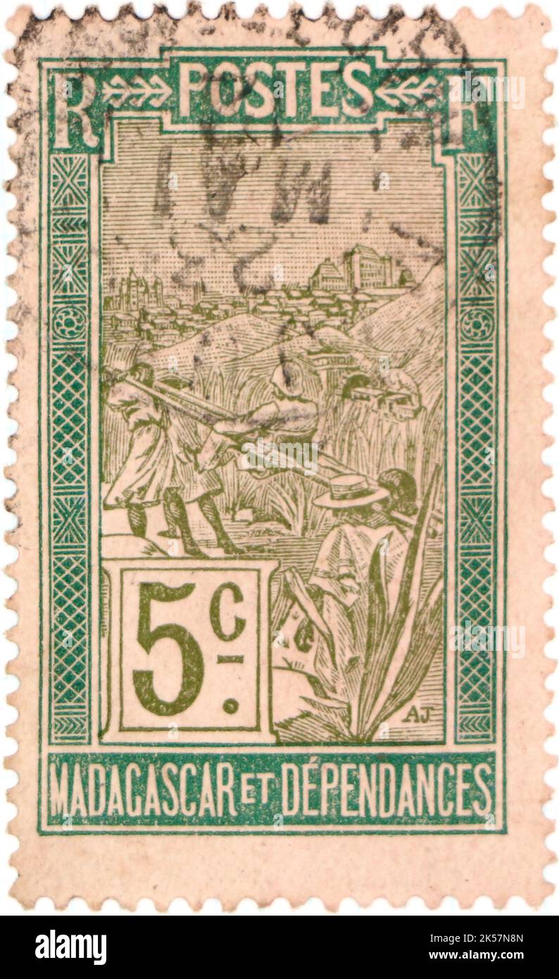 Photo d'un ancien timbre-poste de Madagascar avec une illustration d'un homme porté dans une chaise de berline Banque D'Images
