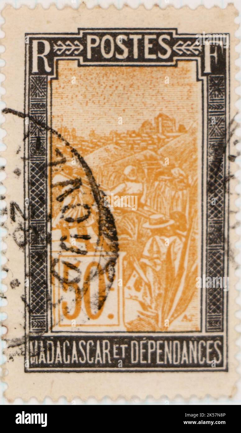 Photo d'un ancien timbre-poste de Madagascar avec une illustration d'un homme porté dans une chaise de berline Banque D'Images