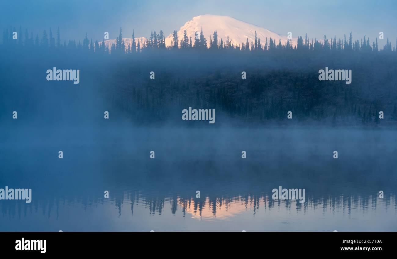 Brouillard et brume tôt le matin sur Twin Lakes à Wrangell-St. Parc national et réserve d'Elias en Alaska. Le mont Sanford s'élève au-dessus des arbres. Banque D'Images