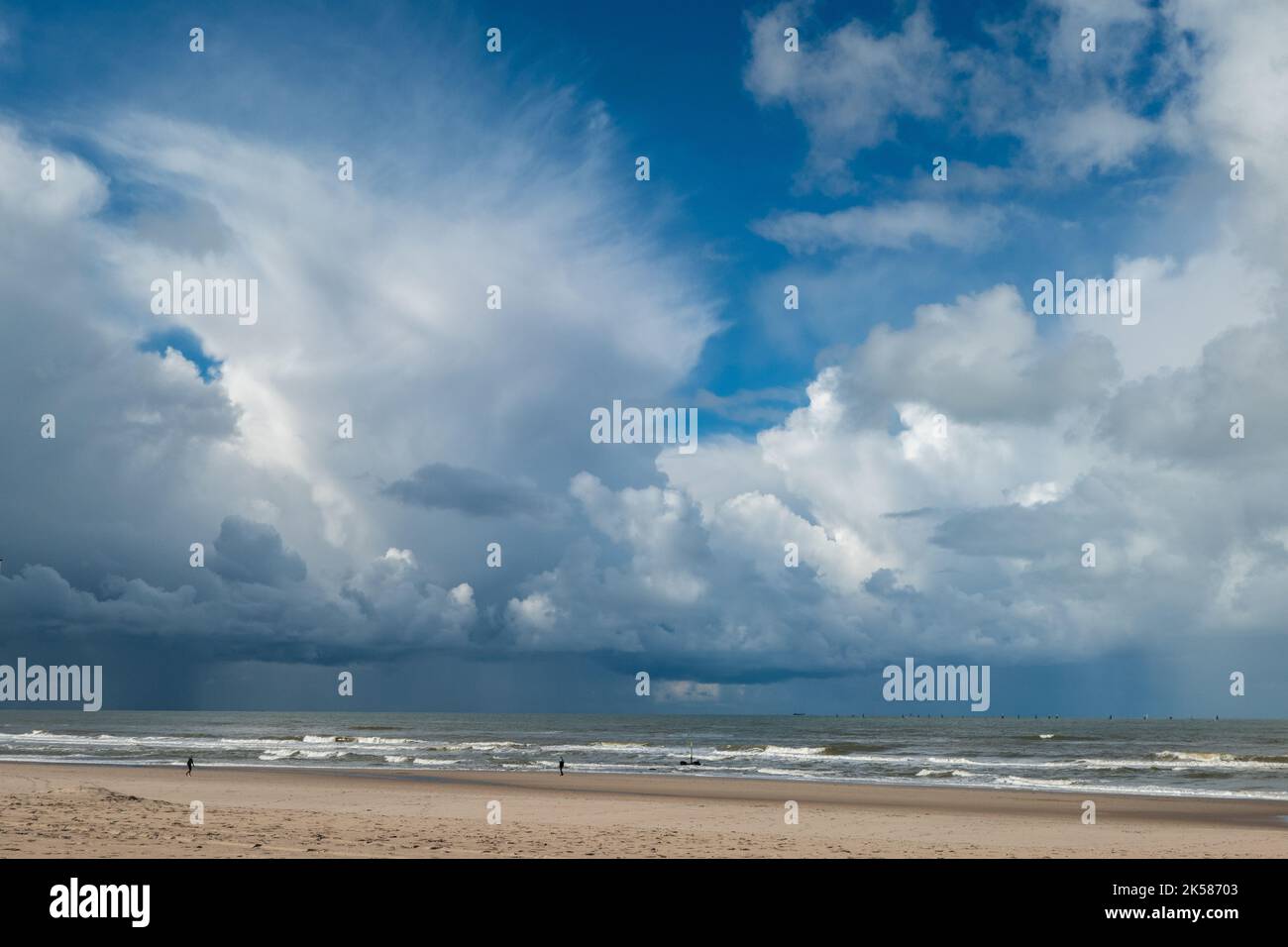 Vue sur la plage avec vagues en mer et nuages sombres en mer en Hollande Banque D'Images