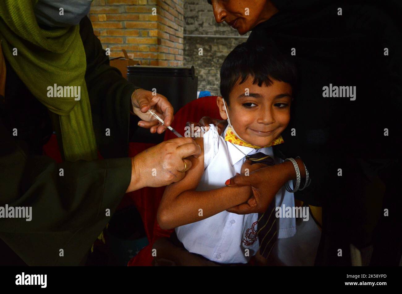 Peshawar, Khyber Pakhtunkhwa, Pakistan. 6th octobre 2022. Un étudiant reçoit un vaccin contre la fièvre typhoïde au cours d'une campagne de vaccination à Peshawar, sur la route de la guerre de l'école modèle de Peshawar. Selon le département de santé, tous les enfants âgés de 9 mois à 15 ans seront vaccinés au cours de la première phase de la campagne. (Image de crédit : © Hussain Ali/Pacific Press via ZUMA Press Wire) Banque D'Images