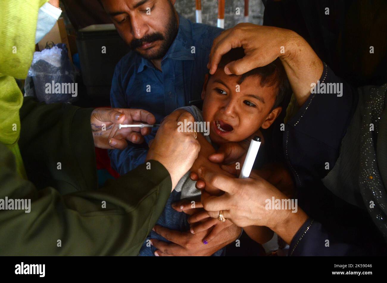 Peshawar, Khyber Pakhtunkhwa, Pakistan. 6th octobre 2022. Un étudiant reçoit un vaccin contre la fièvre typhoïde au cours d'une campagne de vaccination à Peshawar, sur la route de la guerre de l'école modèle de Peshawar. Selon le département de santé, tous les enfants âgés de 9 mois à 15 ans seront vaccinés au cours de la première phase de la campagne. (Image de crédit : © Hussain Ali/Pacific Press via ZUMA Press Wire) Banque D'Images