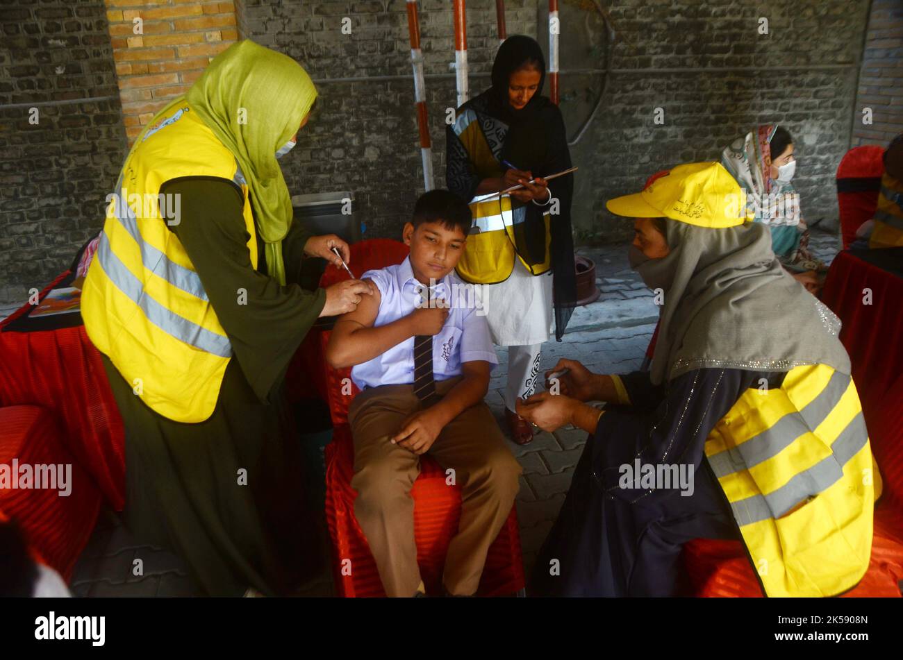 Peshawar, Khyber Pakhtunkhwa, Pakistan. 6th octobre 2022. Un étudiant reçoit un vaccin contre la fièvre typhoïde au cours d'une campagne de vaccination à Peshawar, sur la route de la guerre de l'école modèle de Peshawar. Selon le département de santé, tous les enfants âgés de 9 mois à 15 ans seront vaccinés au cours de la première phase de la campagne. (Image de crédit : © Hussain Ali/Pacific Press via ZUMA Press Wire) Banque D'Images