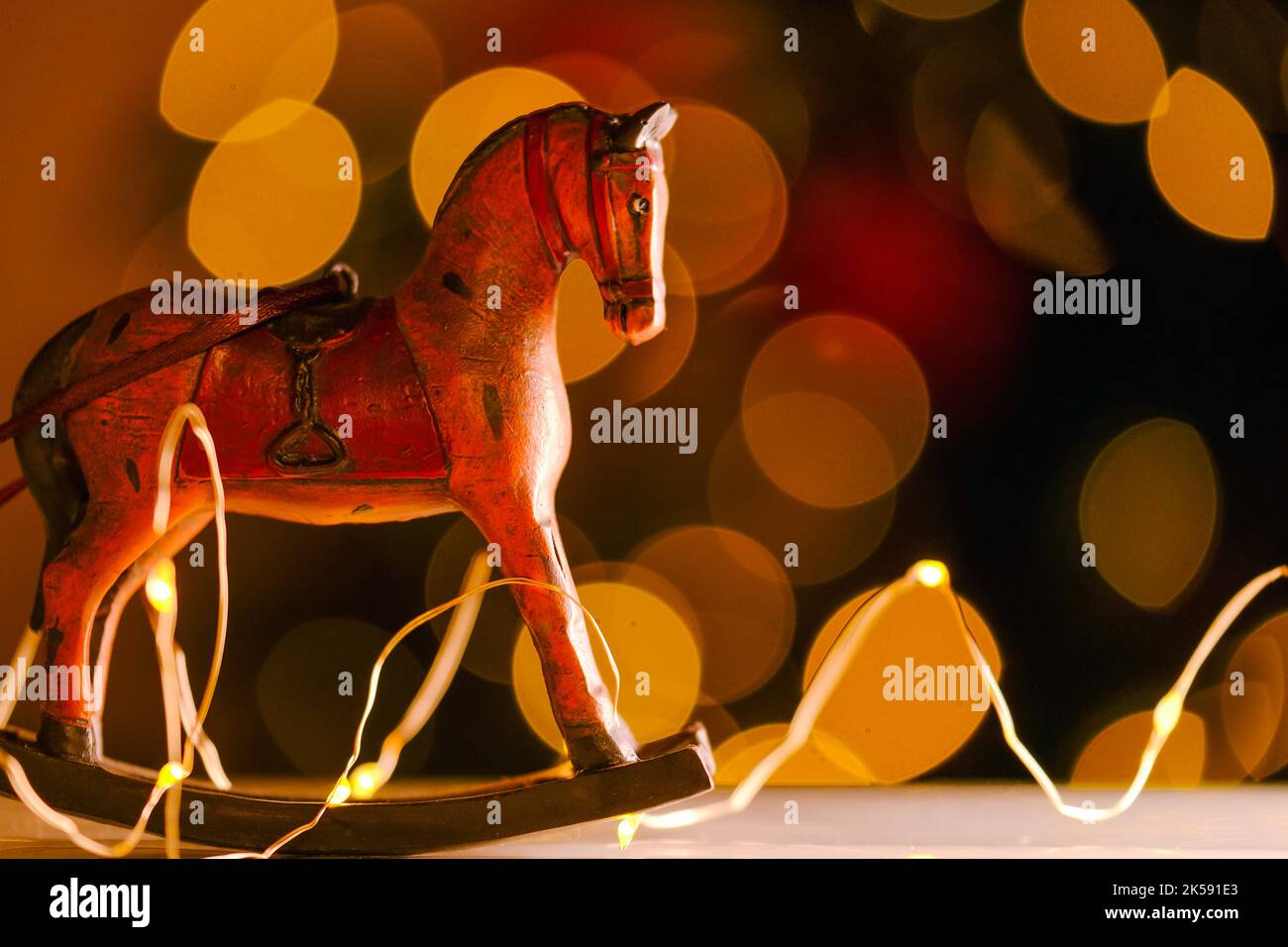 Jouets d'arbre de Noël dans un style vintage.fond de Noël et de nouvel an. Cheval en bois sur fond de guirlandes brillantes.décor de Noël Banque D'Images