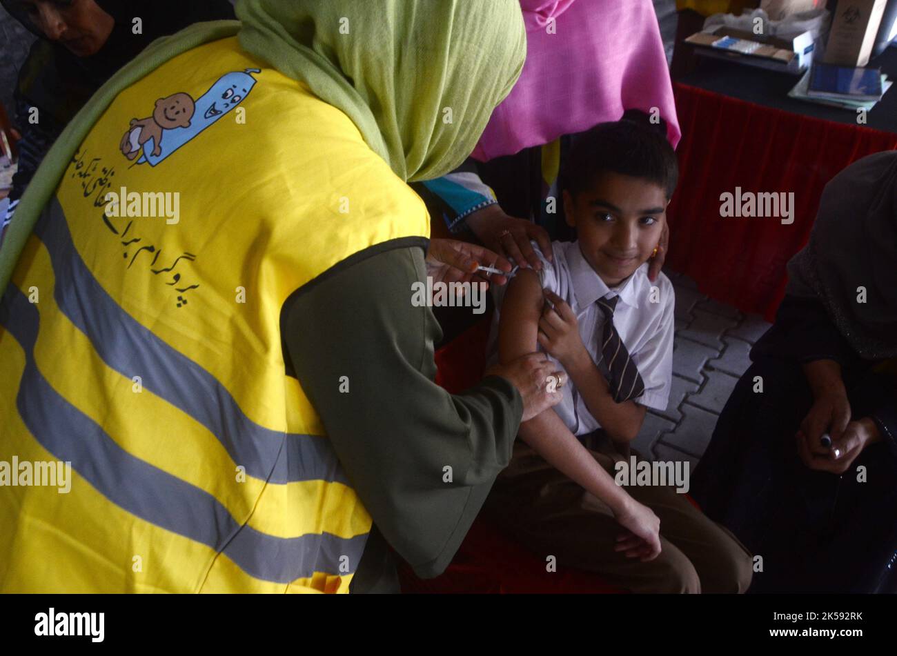 Peshawar, Khyber Pakhtunkhwa, Pakistan. 6th octobre 2022. Un étudiant reçoit un vaccin contre la fièvre typhoïde au cours d'une campagne de vaccination à Peshawar, sur la route de la guerre de l'école modèle de Peshawar. Selon le département de santé, tous les enfants âgés de 9 mois à 15 ans seront vaccinés au cours de la première phase de la campagne. (Image de crédit : © Hussain Ali/Pacific Press via ZUMA Press Wire) Banque D'Images