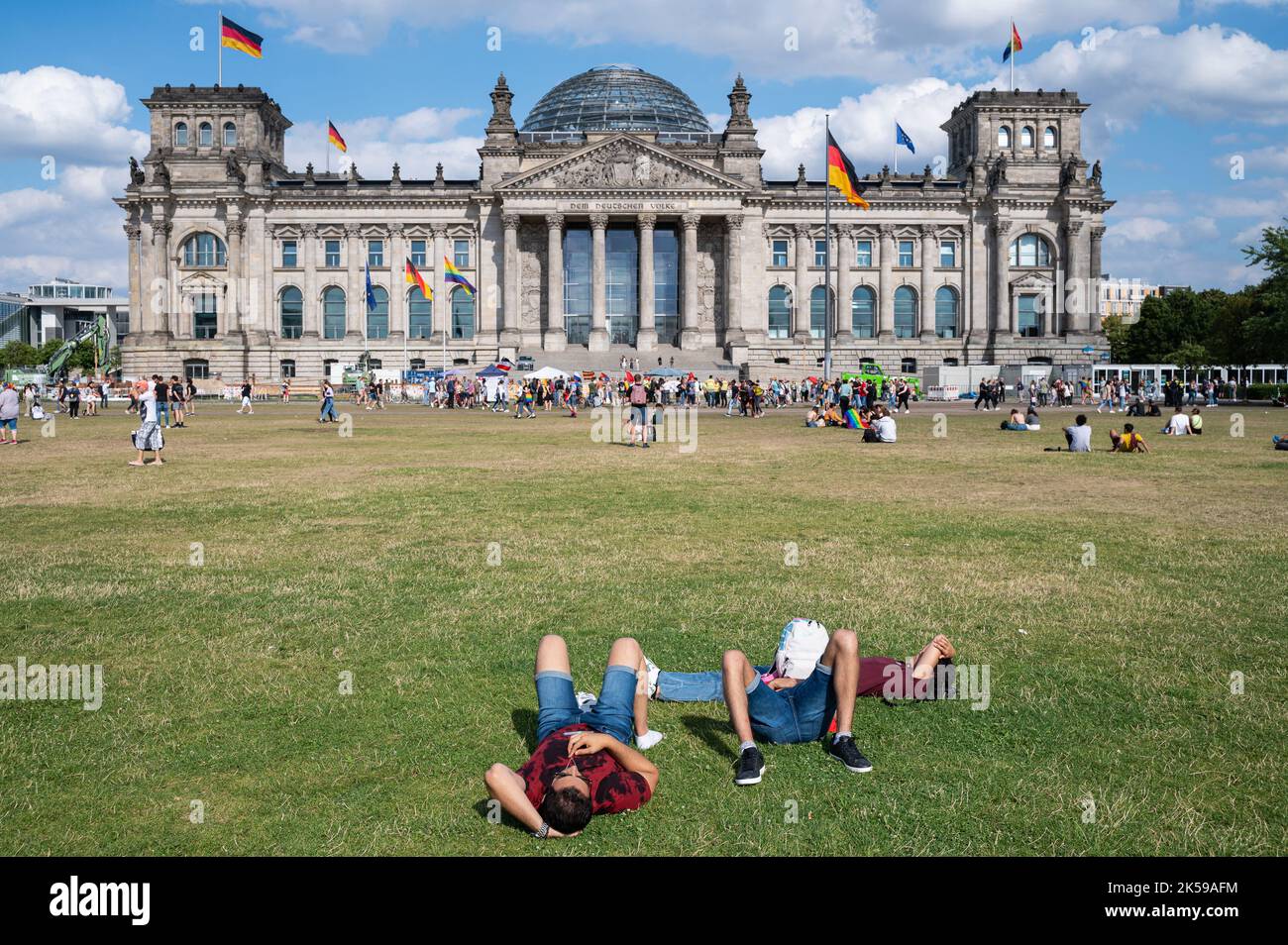 23.07.2022, Allemagne, Berlin - les gens se trouvent sur la pelouse en face du Reichstag, la place de la République dans le quartier de Mitte, profitant d'une journée d'été ensoleillée Banque D'Images