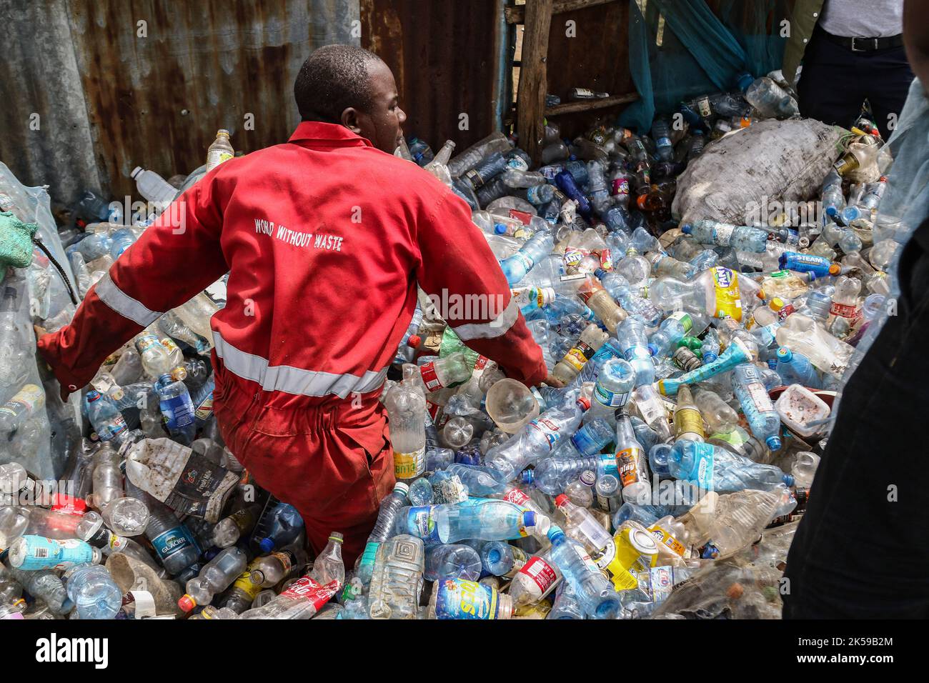 Kisumu, Nyanza, Kenya. 4th octobre 2022. Un homme portant une société de coca-coca rouge globalement brodée avec les mots ''World Without Waste'' est vu travailler dans un centre de collecte des déchets en plastique à Kisumu. Des militants et des groupes environnementaux au Kenya et dans d'autres parties du monde ont dénoncé la société Coca-Cola qui serait nommée sponsor du sommet climatique de cette année, la CdP 27, qui se tiendra en novembre en Egypte. (Image de crédit : © James Wakibia/SOPA Images via ZUMA Press Wire) Banque D'Images