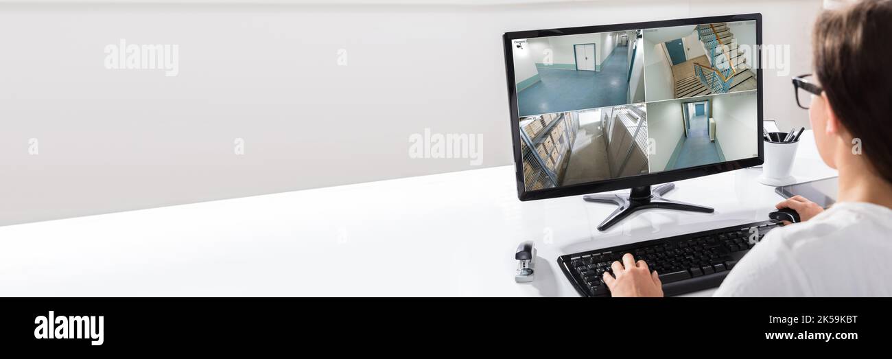 Personne regardant des vidéos de vidéosurveillance sur écran d'ordinateur Banque D'Images