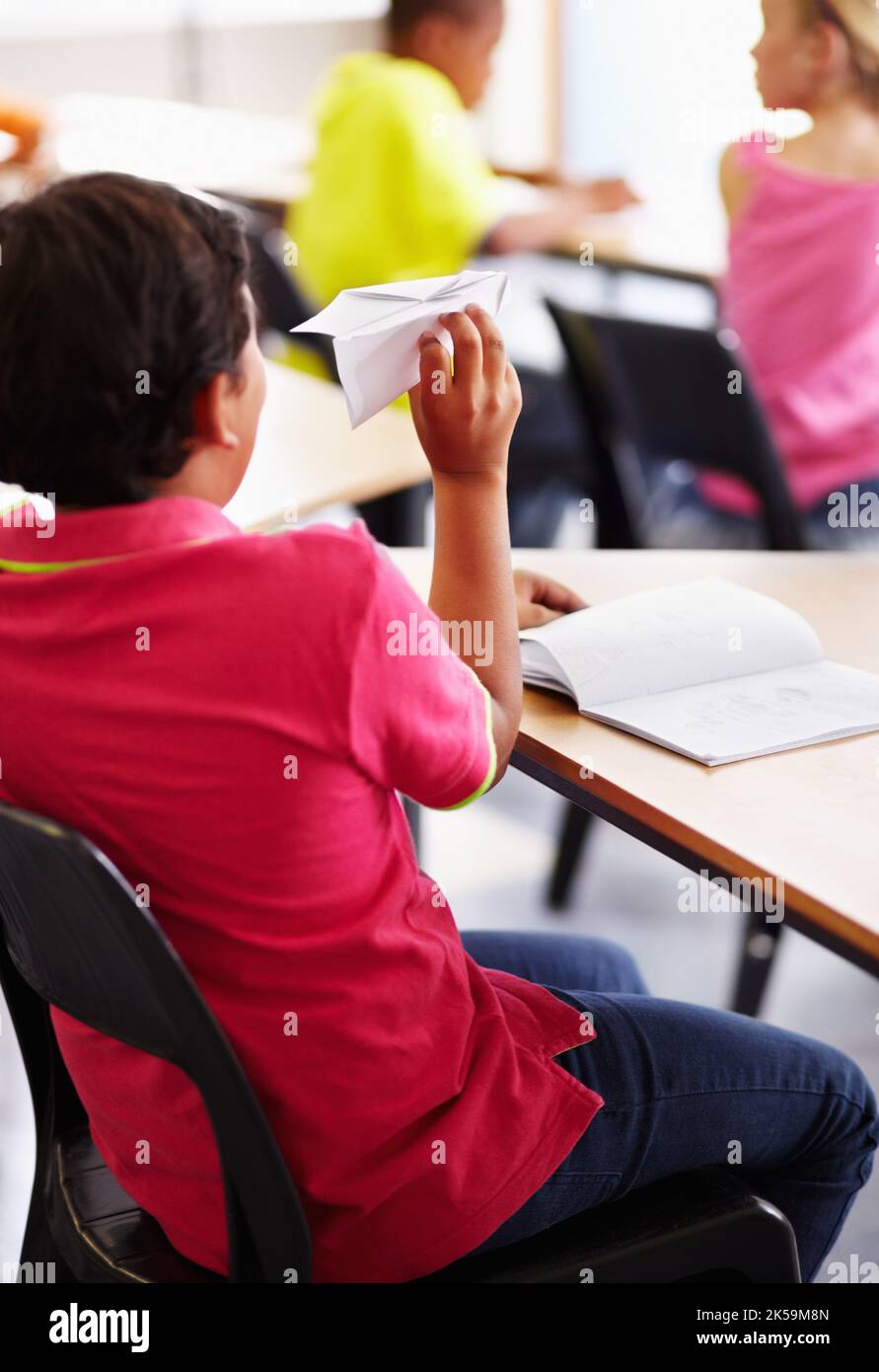 Un message à cette fille. Un garçon indien tenant un avion en papier en classe. Banque D'Images