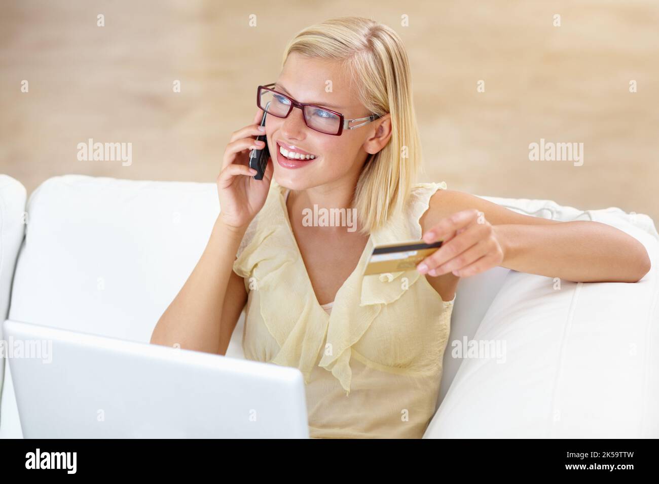 Une thérapie au détail dans le confort de la maison. Une jeune femme magnifique achetant quelque chose en ligne avec sa carte de crédit. Banque D'Images