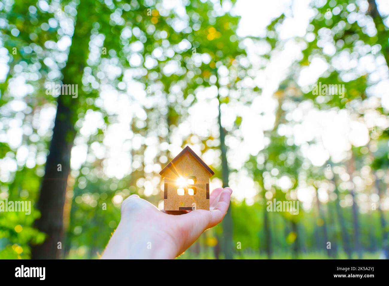 Petite maison en bois à la main à l'extérieur. La lumière du soleil passe par la fenêtre. Banque D'Images
