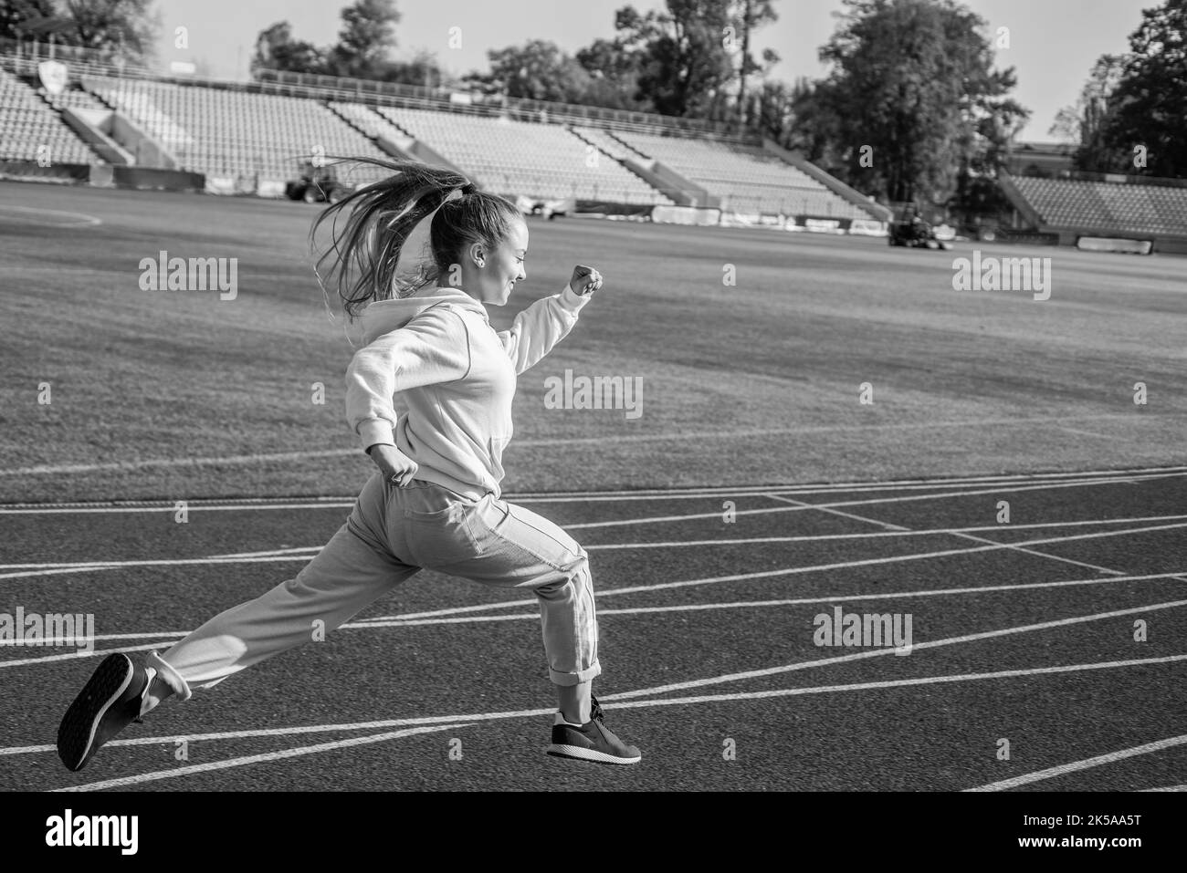 La règle en cours d'exécution est juste exécutée. Une jeune fille énergique court sur la piste de course. École de sport Banque D'Images