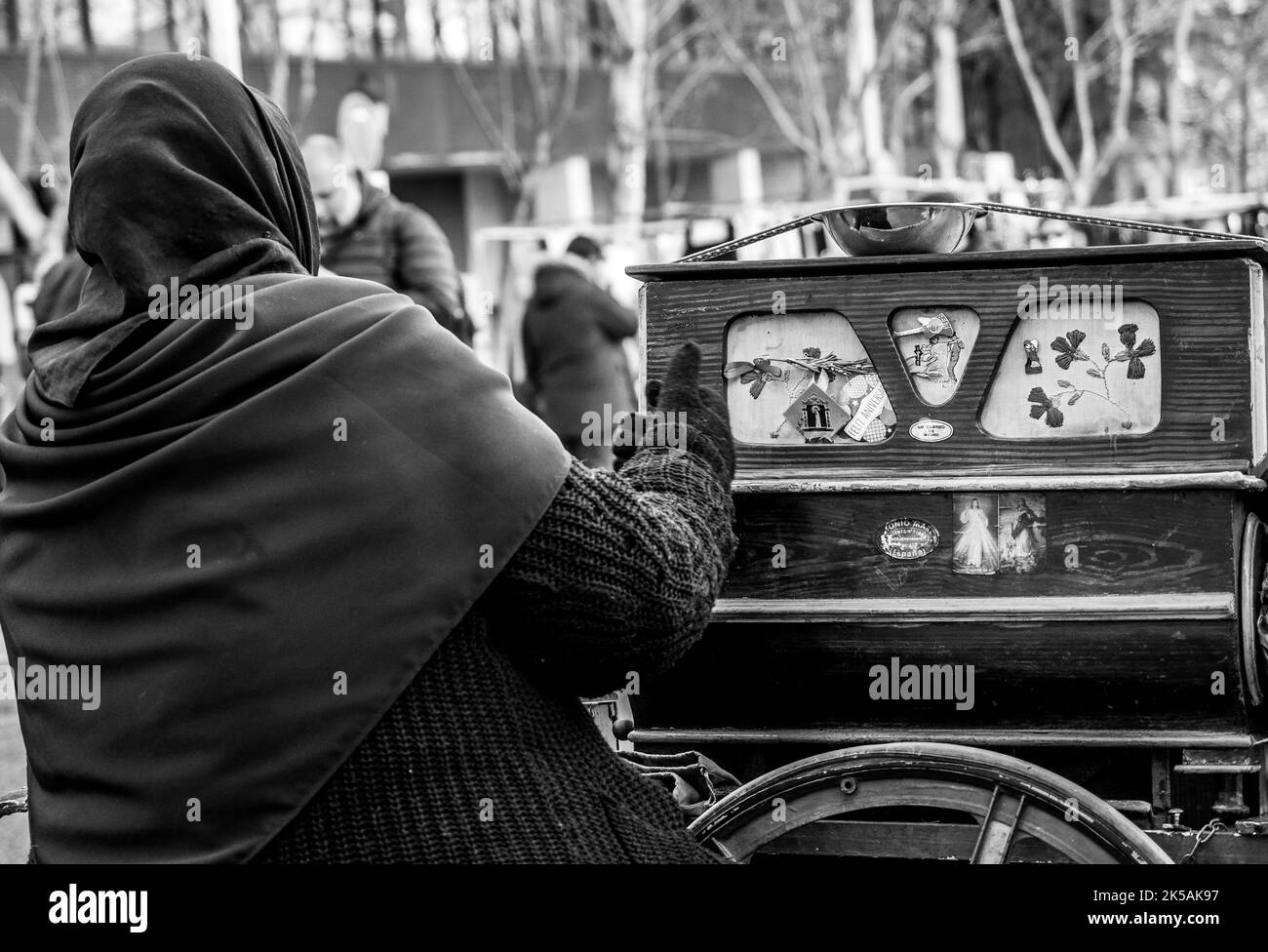 Photographie en noir et blanc d'une gitane méconnue debout dans la rue avec son orgue. Banque D'Images