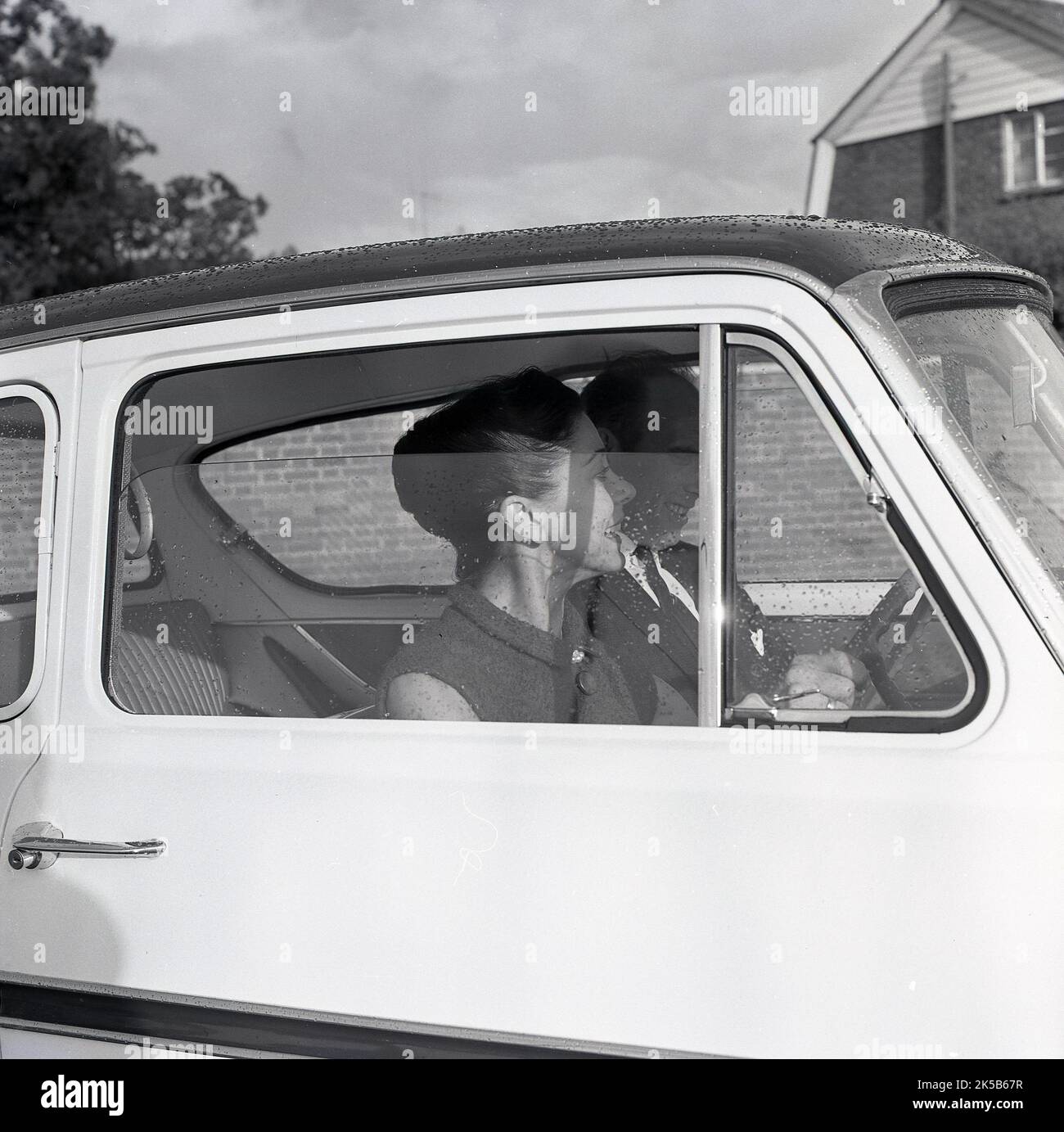 1964, historique, une vue à travers une fenêtre de voiture de la célèbre ballerine anglaise Margot Fonteyn conduite, peut-être, une Ford Anglia. Il est probable que la photo ait été prise près de l'hôpital Stoke Mandeville de Buckinghamshire, Angleterre, Royaume-Uni, où son mari, Roberto Arias, Un politisé pananien qui avait été grièvement blessé dans une tentative d'assassinat, était traité à son Centre national des lésions médullaires. Le 60s a vu Fontyen former un partenariat historique de danse avec le danseur classique russe Rudolf Nureyev. Banque D'Images