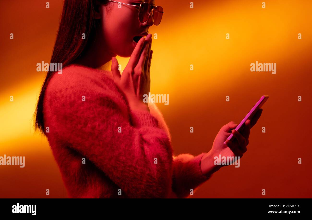 en ligne surprise néon lumière gens fille wow téléphone Banque D'Images