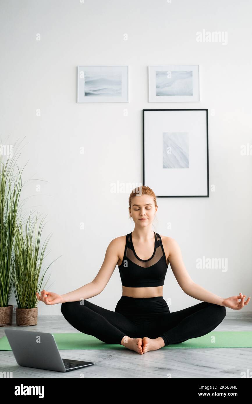 méditation en ligne à la maison yoga paisible femme ordinateur portable Banque D'Images