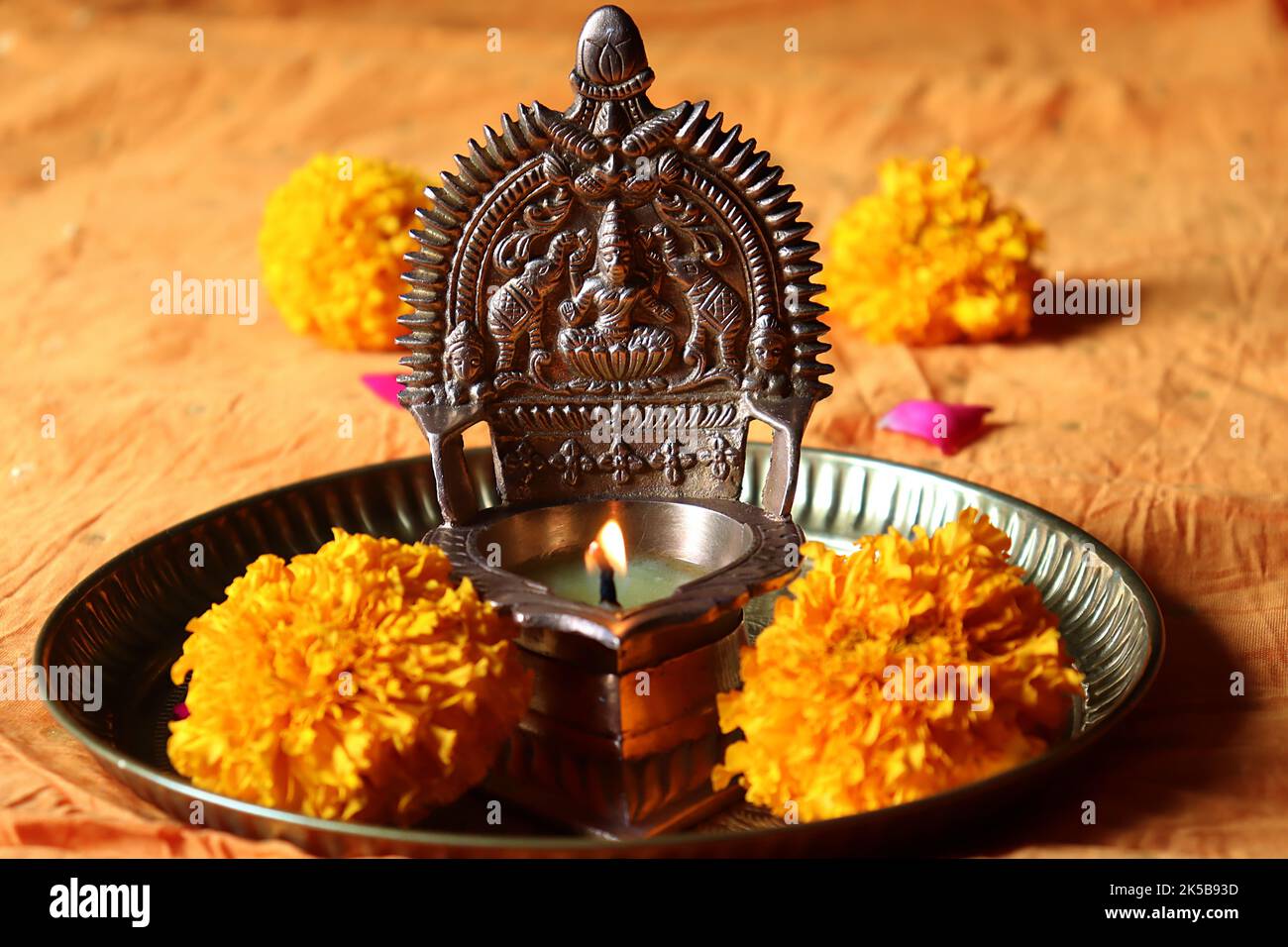 Laiton à l'huile allumé Déesse Lakshmi /Gajalakshmi vilakku dans une plaque de cuivre avec des fleurs marigold/festival Diwali/Deepavali Banque D'Images