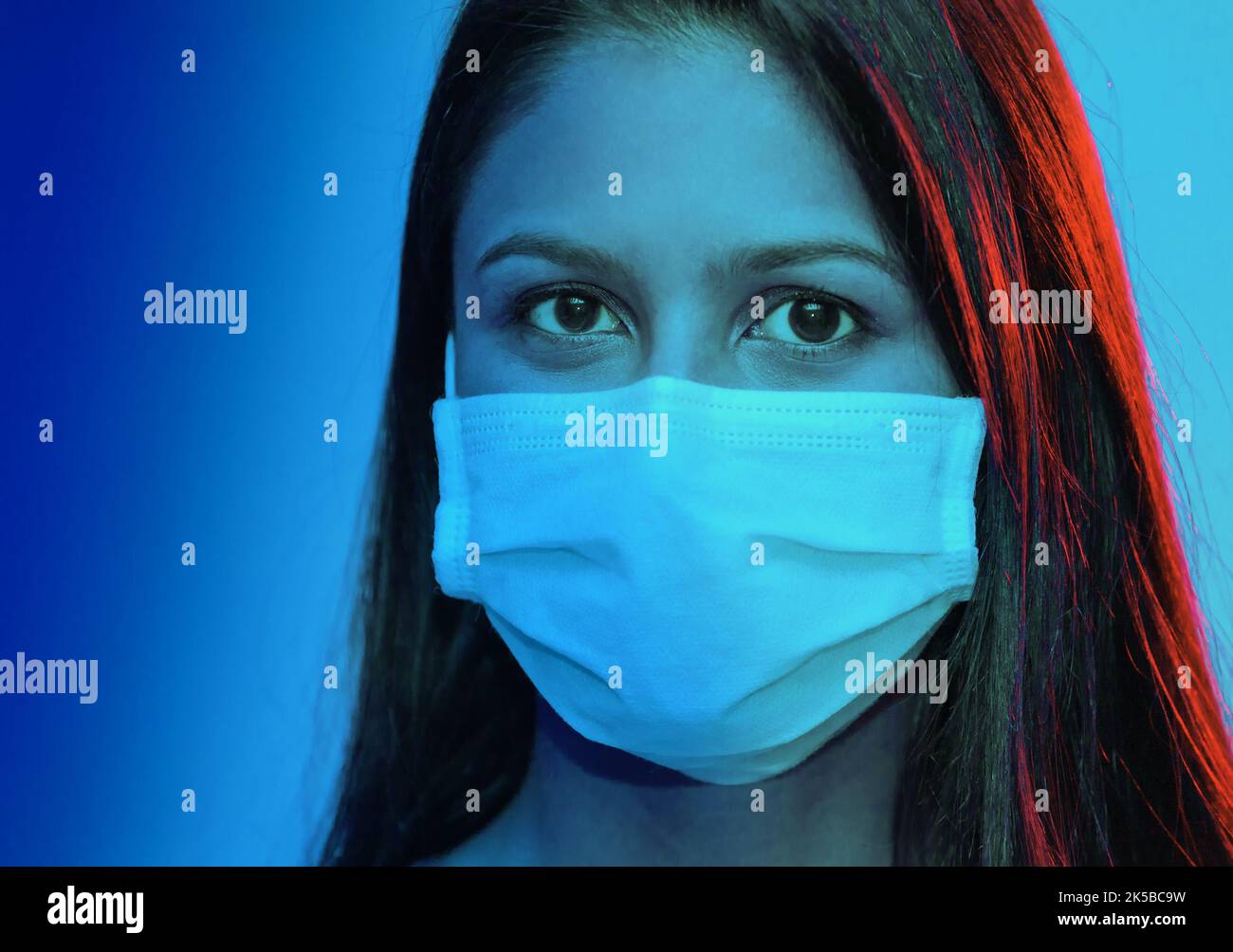 Portrait en deux tons d'une jeune femme portant un masque chirurgical. Concept médical. Banque D'Images