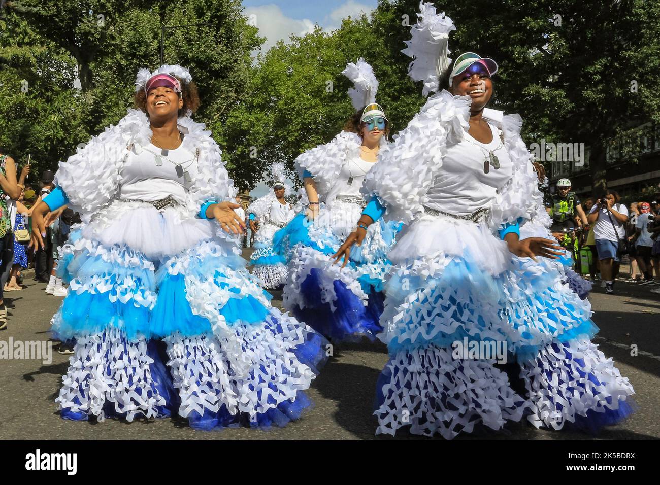 Un groupe de danse en costumes colorés participe à la parade de jour de famille, Notting Hill Carnival, Londres Banque D'Images