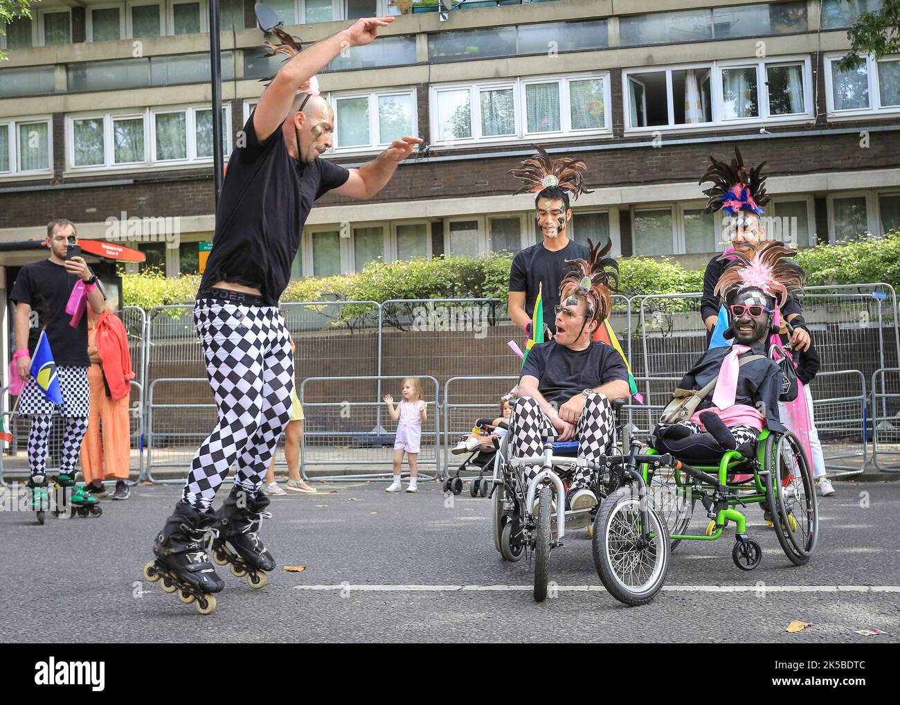 Un groupe de patineurs à roulettes, y compris des utilisateurs de fauteuils roulants, se manifeste au Notting Hill Carnival Parade, Londres, Angleterre, Royaume-Uni Banque D'Images