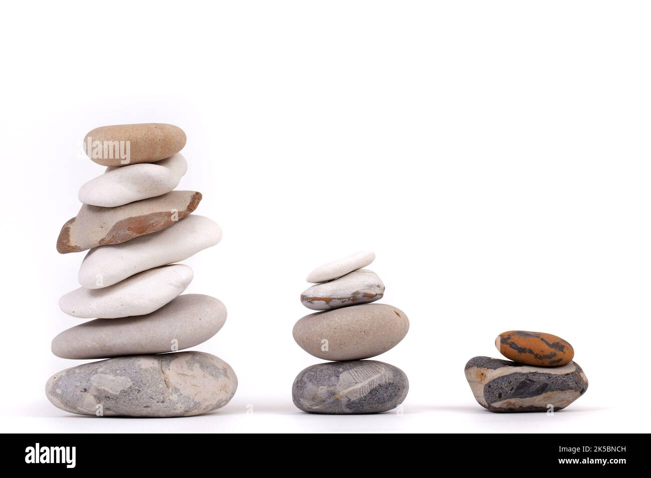 Colonnes de galets de hauteur différente isolées sur blanc. Concept de relaxation et de méditation zen Banque D'Images